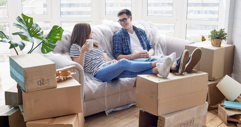 couple on sofa with boxes in room